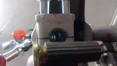 Si quitas la rueda delantera, debajo aparece un tornillo de allen, yo solo pude aflojar uno de los 2
